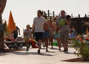 Jason (Lee Ingleby, l.) und Ben (Daniel Ryan, r.) sowie die Kinder Kimberly (Skye Grimsey) und Sunil (Viaan Mayur) werden von den Attentätern am Pool überrascht.