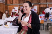 Marianne Grasegger (Ursula Maria Burkhart) genießt das Essen auf dem Rosenheimer Brat-wurstwettbewerb.