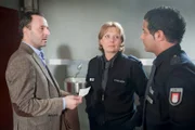 Heiner Bartels (Robert Schupp, l.) bestreitet gegenüber Tarik (Serhat Cokgezen, r.) und Claudia (Janette Rauch, M.), dass es Gründe für den Anschlag auf seinen Wagen geben könnte.
