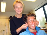 Willi beim Perückenaufsetzen mit Bianca