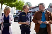 Polizeihauptmeister Mohr (Max Müller, M.) informiert die Kommissare Danner (Katharina Abt, l.) und Stadler (Dieter Fischer, r.) über erste Erkenntnisse zum Mordopfer.