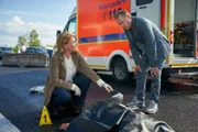 Marie Brand (Mariele Millowitsch, l.) und ihr Kollege Jürgen Simmel (Hinnerk Schönemann, r.) begutachten den Tatort und die Leiche von Claudio Messina (Sami Loris, M.).