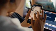 Einstein Botox, Filter und KI: Schönheit im digitalen Zeitalter Eine Frau macht Korrekturen an einem Bild in einer App.