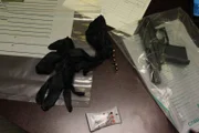 Gloves, bullets, a handgun, and test pouches lay on the table as agents gather up the evidence. (National Geographic/Lucky 8 TV)