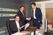 Richard (Karim Köster, l.) muss eine Niederlage einstecken, als der Finanzprüfer (Helmut Finke, M.) David (Mathis Künzler, r.) zu seinen makellos geführten Büchern gratuliert.