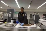 Officer Arrisia Sima inspects commodity  for potential pests. (National Geographic/Lucky 8 TV)