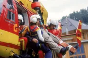 Der verletzte Jost Balzer (Holger Kunkel) wird von Gina Aigner (Julia Cencig) und Mark Harland (Urs Remond) aus Medicopter geladen.