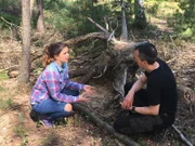 Tierforscher Lars zeigt Anna eine Huderstelle. In diesen Sandbädern gehen Auerhühner der Federpflege nach.