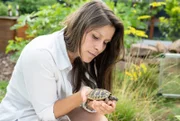 Gastgeberin Jacky Uda mit einer von sechs jungen griechischen Landschildkröten, die sich im 400qm großen Garten auch wohl fühlen.
