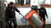 Zwei Mitarbeiter einer Neusser Altmetallentsorgung holen einen alten Heizkessel bei einem Kunden ab.