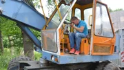 Experte Otto Schulte versucht den Bagger zum Laufen zu bringen.
