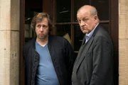 Ekki (Oliver Korittke, l.) und Wilsberg (Leonard Lansink, r.) beobachten das Geschehen vor dem Antiquariat.