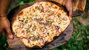 Grits Spezialität: Flammkuchen Elsässer Art aus Dinkelspezialsauerteig mit Zwiebeln, Speck und Äpfeln als Bonuszutat.