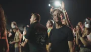 Checker Tobi steht im Publikum beim Konzert der Band "Die Ärzte" und genießt die Show.