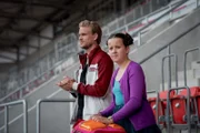 Rike (Madeleine Haas, re.) ist auf Recherche im Stadion.