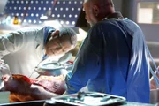 Dr. Raymond Langston (Laurence Fishburne, l.) und Dr. Robbins (Robert David Hall) untersuchen den Körper des Opfers.