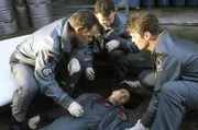 Alex (Matthias Leja, l.), Thomas (Ulrich Bähnk, M.) und Wollcke (Oliver Hörner, r.) wollen "ihre" Ärztin Ilona (Julia Heinemann, liegend) selbst ins Krankenhaus fliegen.