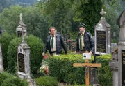 Hubert (Christian Tramitz, links) und Staller (Helmfried von Lüttichau) schauen auf dem Friedhof nach dem Rechten, da sie einen anonymen Anruf erhalten haben, dass das Grabkreuz von Hanna Mithuber vom Sockel geschlagen wurde.