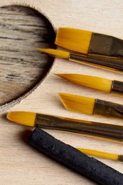 Paintbrushes and charcoal on palette