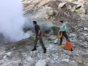 Rob Nelson and Stefan Burns both gaze into the opening of a fumarole as it emits large quantities of steam.