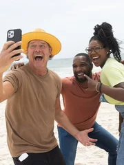 Mentor Ty Pennington (l.) celebrates winning the main suite challenge by taking a selfie with his team of Ashley (r.) and Steven (m.).