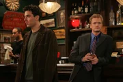 Bei einem gemeinsamen Bar Besuch mit Barney (Neil Patrick Harris, r.) lernt Ted (Josh Radnor, l.) die hübsche Fernsehreporterin Robin kennen und ist wie verzaubert von ihr ...