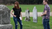 Amy Bruni and Adam Berry look over to something in a cemetery.