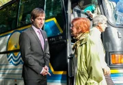 Der Veranstalter der Kaffeefahrt Steffen Brandl (Niels Bruno Schmidt, links) begrüßt eine Gruppe Rentner (Komparsen) zu einer Verkaufsveranstaltung.