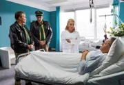 Girwidz (Michael Brandner, rechts) muss wegen einer Lebensmittelvergiftung die Ermittlungen vom Krankenhaus aus leiten. Ohne Uniform nehmen ihn Hubert (Christian Tramitz, links) und Staller (Helmfried von Lüttichau, 2. von links) nicht ernst (mit Karin Thaler).