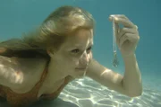 Emma (Claire Holt) entdeckt am Meeresboden eine Kette mit einem Medaillon.
