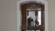 Police officers search a desk.