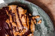 Vögala sind das "Wohlfühlessen" von Andrea Drey aus dem Raum Günzburg. Die kleinen Nester aus Schnittlauch-Pfannkuchen mit einer Füllung aus Brät sind ein altes schwäbisches Rezept, das schon ihre Oma gern zubereitet hat. Vroni Lutz inspirieren die Vögala zu einem Auflauf aus gefüllten Basilikum-Pfannkuchen mit einer Ricotta-Spinat-Mischung, gebacken in Tomaten-Sauce. Dann wird es richtig süß: Als Dessert kredenzt Vroni eine Art Torte aus Bananen-Pfannkuchen, mit Milchkaramell, Schokosoße, Vanilleeis und Walnuss-Topping (im Bild).