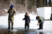 Kaleb Rowland bringt seinen Kindern Gilbert und Elovie das Eisfischen bei. (National Geographic/Sean Odom)