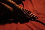 LOS ANGELES, CALIF.- A couple's hands in bed together.