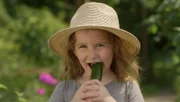 Ida wohnt in der Stadt und hat trotzdem einen Garten. Dort isst sie eine selbst geerntete Gurke.