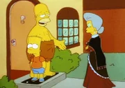 Belle (re.) beschwert sich bei Homer über seinen ungezogenen Sohn Bart.