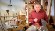 Prof. Dr. Matthias Wemhoff mit einer Legionärssandale in der rekonstruierten römischen Schuhmacher-Werkstatt auf der Saalburg.