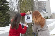 Zwei Frauen bringen fehlende Plakate von Natasha Cournoyer an.