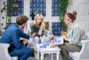 Henry (Elias Reichert,  l.) und Larissa (Vivien Wulf, M., mit Johanna Graen, r.) fällt es schwer, weiter die glücklich Verlobten zu geben.