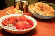 Zu warmer roter Kubbeh-Suppe wird im Jerusalemer Restaurant „Morduch“ ein Teller mit Pitabrot gereicht.