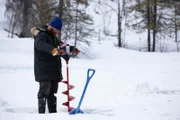 Kaleb Rowland bohrt Löcher unter das Eis des Sees, um Biberfallen aufzustellen. (National Geographic/Sean Odom)