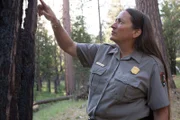 Feuerwehrchefin Kelly Martin begutachtet die Feuerschäden im Wald.