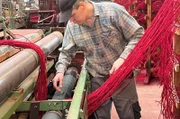 Teppichweberei in der Eifel: 600 Fäden werden einzeln und von Hand in der richtigen Reihenfolge durchgefädelt.