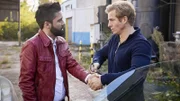 Bollywood-Film-Super-Cop Abishek Roshan (Navid Navid, l.) will die Führung bei der Rettung der Entführten Priya übernehmen, aber nicht mit den Helden. Paul (Daniel Roesner) fesselt den Schauspieler mit Handschellen am Auto.