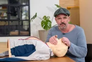 Doc Esser führt an einer Reanimationspuppe vor, wie man eine Mund-zu- Mundbeatmung durchführt.