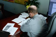 Der Mann am Tisch sieht sich die Papiere an