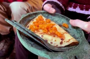 Im lappländischen Ylläsjärvi backt Anja Pfannkuchen in einem Tipi über dem Holzfeuer. Serviert werden diese mit Fichtensirup und arktischen Brombeeren.