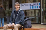 Mirko Hoffmann (Axel Schreiber) wartet auf vor der Sachsenklinik auf seinen Bruder Dr. Kai Hoffmann, um ihm einen Brief ihrer verstorbenen Mutter zu geben.