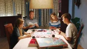 Floor und ihrer Familie (Elisa Beuger, Ferdi Stofmeel, Bobbie Mulder und Ole Kroes) spielt ein altes Brettspiel.