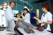 Dr. Iris Brooks (Sarah Masuch, liegend) wird nach einem Autounfall in die Sachsenklinik eingeliefert. Während Dr. Martin Stein (Bernhard Bettermann, li.) und Schwester Ulrike (Anita Vulesica, re.) Iris untersuchen, kommt Dr. Maria Weber (Annett Renneberg, 2.v.re.) dazu.